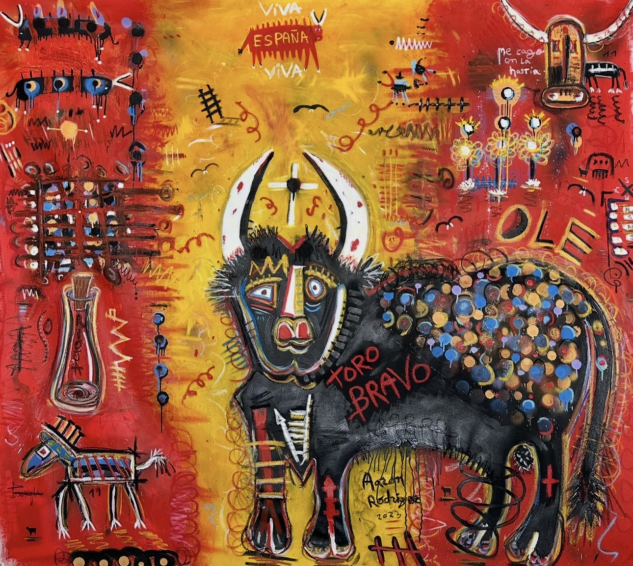 Neo-expressionist painting: a black bull with white horns and a crown-like mark stands at the centre against a yellow glow, its flank covered in blue, ochre and lilac dots, surrounded by a red field of scrawled lettering ('VIVA ESPAÑA', 'TORO BRAVO', 'OLE'), a small donkey, a bottle, eyes and graffiti-like symbols